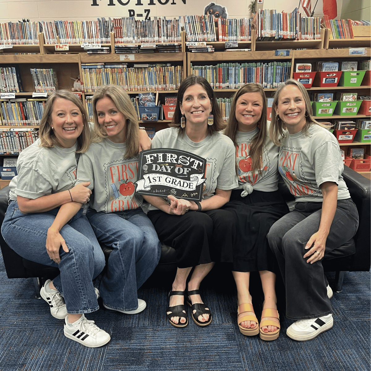 First grade teachers posing on a couch in the Mills Library