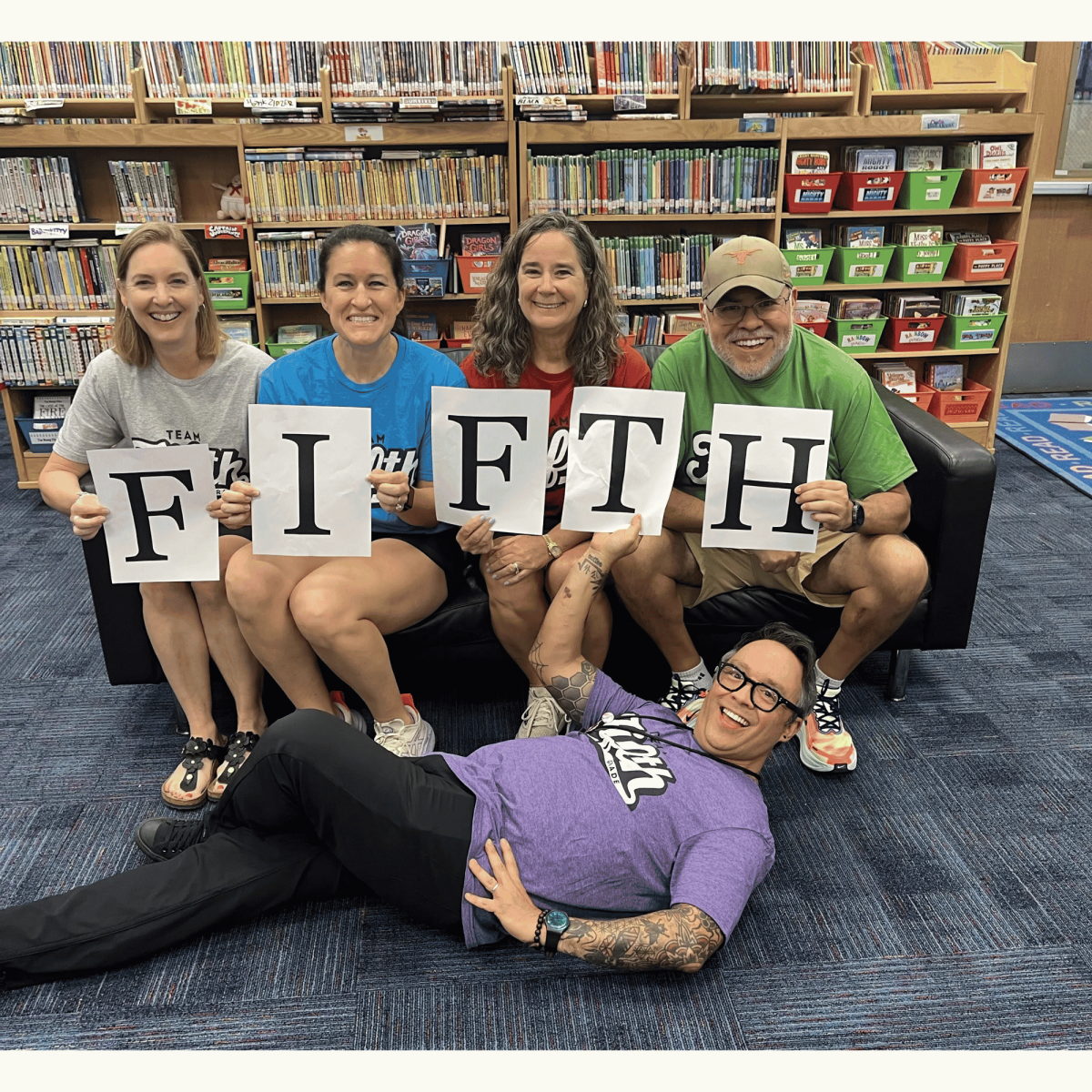 Fifth grade teachers posing on a couch in the Mills Library